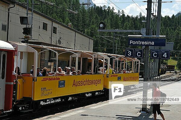 Touristische Attraktion: Reisende und Touristen im Cabriozug am Bahnhof in Pontresina im Oberengadin in den Schweizer Alpen