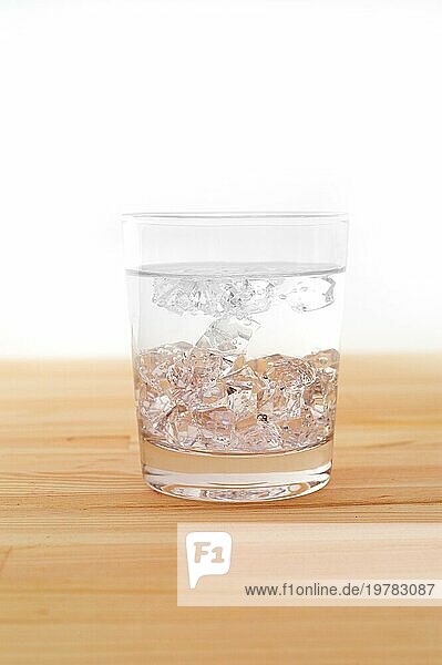 Glas reines Eiswasser über einem Holztisch weißer Hintergrund
