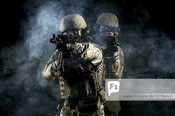 Amerikanische Soldaten in Kampfmunition mit Waffen in den Händen  die mit Laserzielgeräten ausgestattet sind  befinden sich in Schlachtordnung. Gemischte Medien