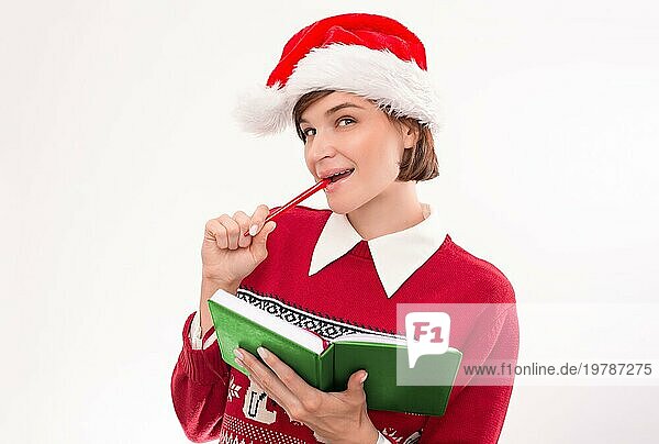 Bild einer Frau in Weihnachtskleidung auf weißem Hintergrund. Sie macht einen Wunschzettel. Feiertags Konzept. Gemischte Medien
