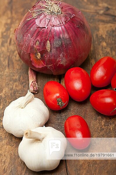 Zwiebel Knoblauch Tomaten Grundlagen der italienischen Küche auf rustikalem Tisch