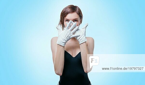 Verwirrtes Mädchen mit weißen Handschuhen  das im Studio vor einem weißen Hintergrund posiert. Porträt ohne Namen