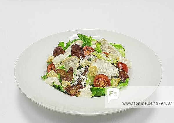 Gourmet Caesar Salat mit Speck. Ansicht von oben. Weißer Hintergrund. Gesunde Ernährung Konzept.