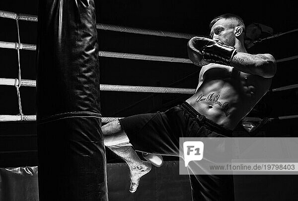 Kickboxer schlägt mit dem Knie auf den Sandsack. Die Ausbildung eines Profisportlers. Das Konzept von MMA  Wrestling  Muay Thai.