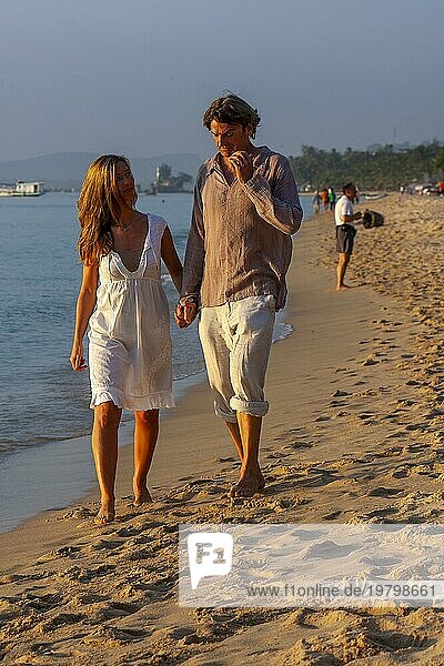Junges Paar spaziert am Strand  Mann und Frau Hand in Hand