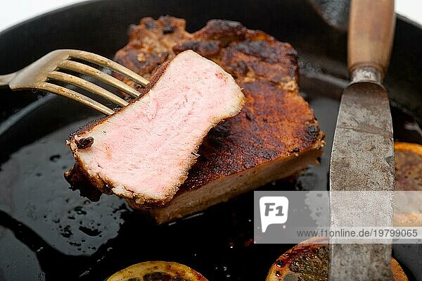 Schweinekotelett auf Eisenpfanne mit Zitrone und Gewürzen gebraten  Food photography  Food photography