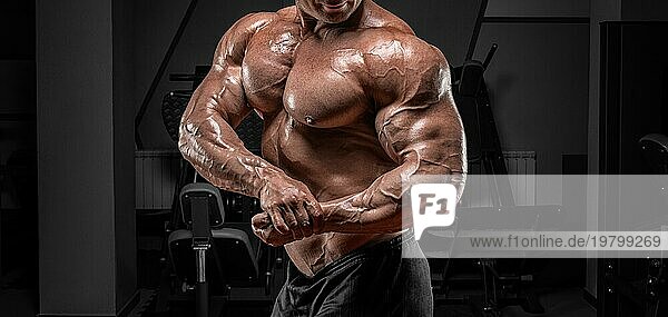 Kräftiger Bodybuilder posiert in der Turnhalle. No name portrait. Bodybuilding Konzept.