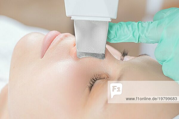 Junge hübsche Frau  die in einem Schönheitssalon behandelt wird. Ultraschall Reinigungsverfahren. Hardware Kosmetologie.