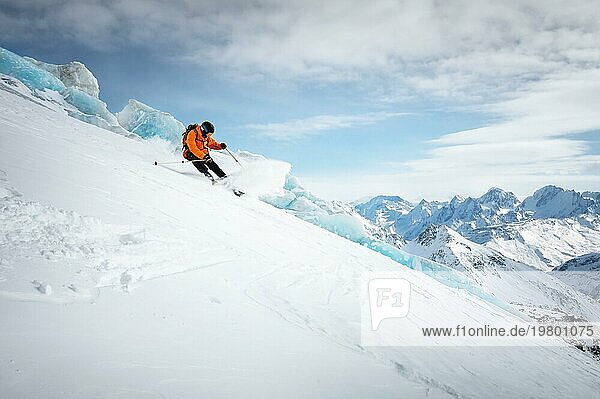 Professionelle Skifahrer Fahrt mit Geschwindigkeit auf einer verschneiten Piste vor dem Hintergrund eines Gletschers und hohe schneebedeckte Berge an einem sonnigen Tag. Skigebiet Raum Kopie Präsentation