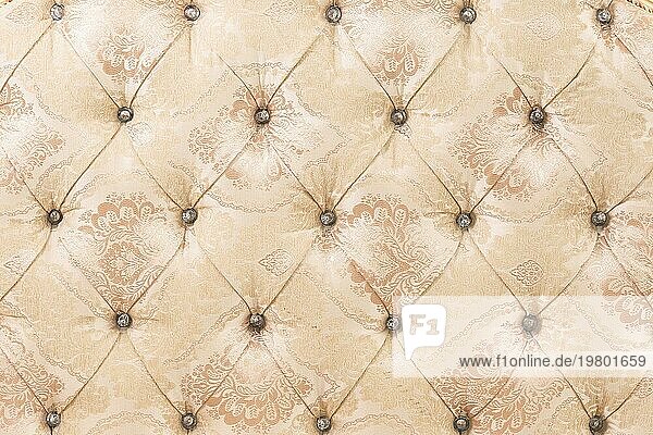 Beige weichen Wandteppich Muster Hintergrund mit symmetrischen Tasten an den Ecken der Diamanten. Weiche und teure Möbelelemente. Luxus Hintergrund