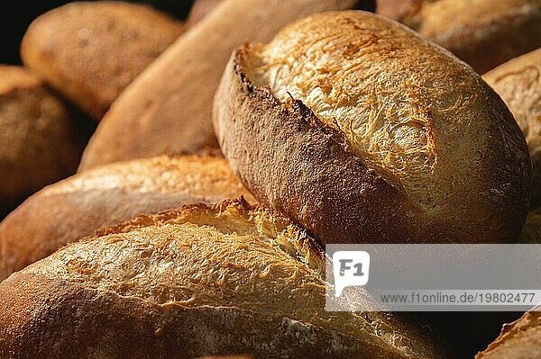 Frisches  knuspriges  heißes  leckeres  handwerklich hergestelltes Brot. Viele Brote liegen auf einer Holzpalette