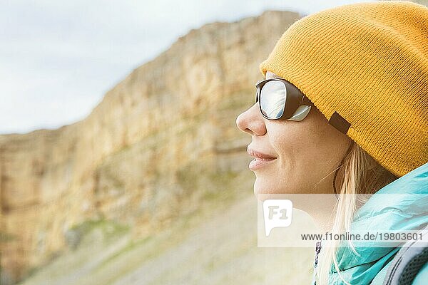 Close up Porträt eines Mädchens Reisende in einem Hut und Klettern Sonnenbrille. Glückliches Mädchen auf dem Hintergrund von Felsen