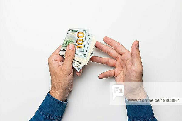Geschäftsmann hält einen Stapel Eurobanknoten in der Hand und zeigt mit dem Finger auf Geld  Einkommen  Erfolg