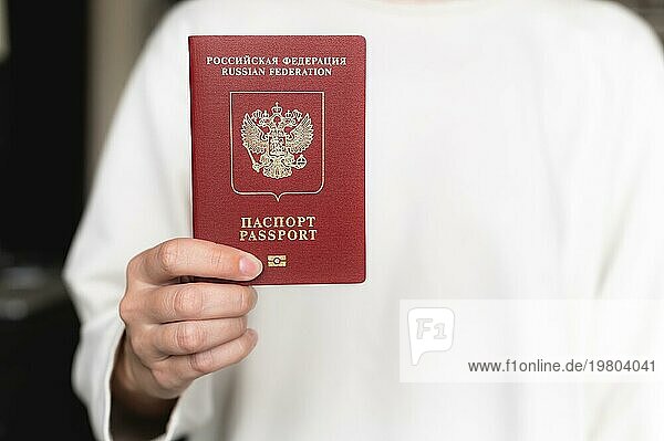 Reisepass der Russischen Föderation. Menschliche Hand mit russischem Pass Nahaufnahme  selektiver Fokus  Unschärfe. Reisepass