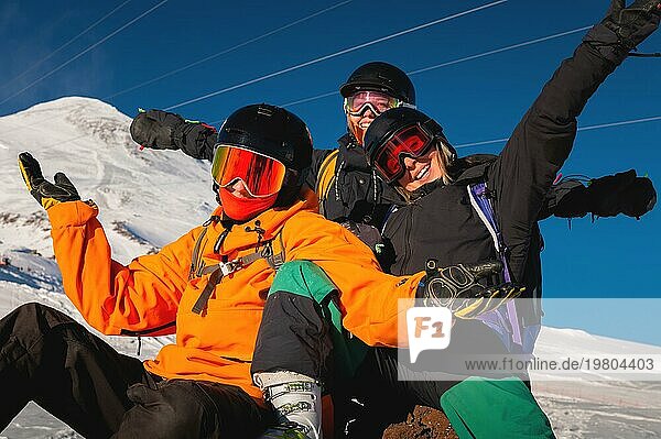 Lachende Freunde im Winterurlaub beim Skifahren in verschneiten Bergen  Blick in die Kamera. Eine Gesellschaft von Menschen genießt einen Winterurlaub in einem Skigebiet
