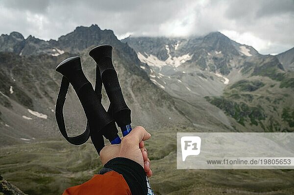 Nahaufnahme von Frauenhänden mit Trekkingstöcken für Nordic Walking vor dem Hintergrund der alpinen Berge  entfernte kaukasische Felsen