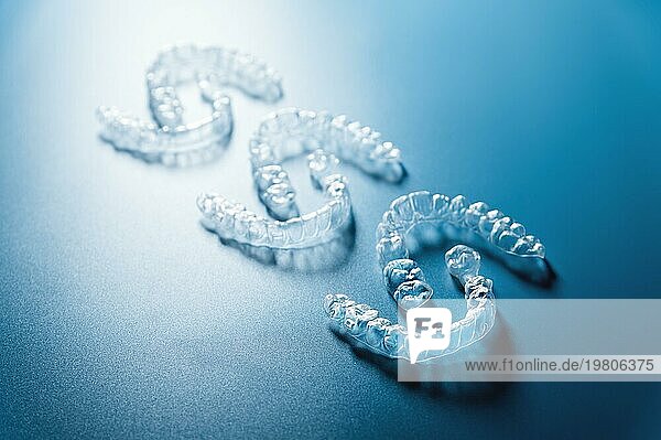 Unsichtbare Kunststoff Glätteisen liegen in einem Muster einander gegenüber  Platz für Text für eine Zahnklinik