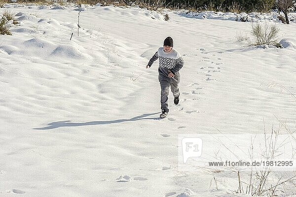 Junger Mann hat Spaß beim Laufen im großen Schnee