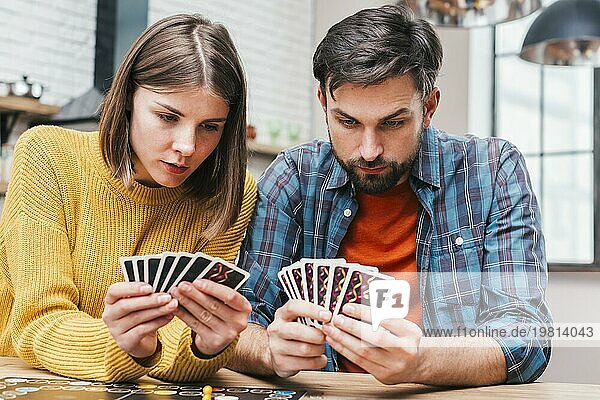 Seriöses junges Paar  das seine Karten beim Brettspiel betrachtet