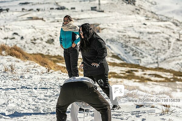 Drei junge Latinos spielen im Schnee in den Bergen von Sierra Nevada