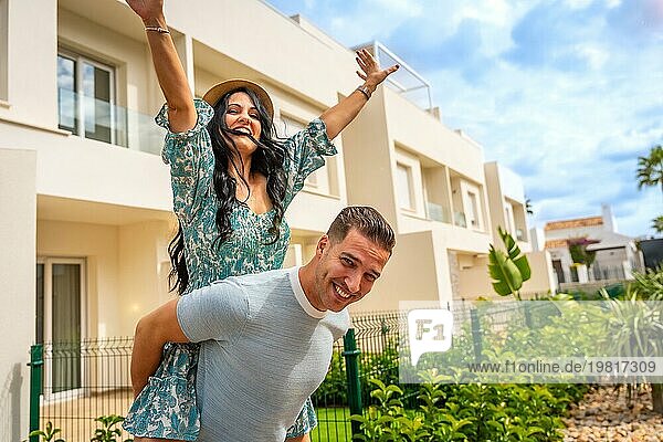 Ein glückliches  frisch verheiratetes Paar feiert den Kauf eines Hauses  das direkt neben seinem neuen Grundstück steht