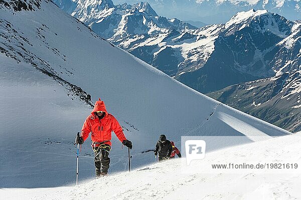 Der Bergsteiger erklimmt den schneebedeckten Gipfel. Das Konzept  Schwierigkeiten zu überwinden und das Ziel zu erreichen