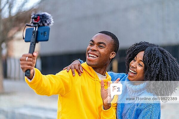 Junge Afrikaner lächeln während eines Live Streams auf der Straße