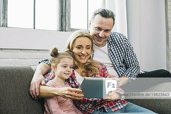 Glückliche Familie mit digitalem Tablet Sofa Wohnzimmer