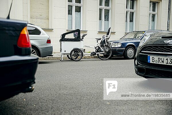 Symbolfoto zum Thema Parkplätze für Fahrräder in der Stadt. Ein Lastenrad parkt auf einer Straße in Berlin Mitte zwischen zwei Autos auf einem Parkplatz. Berlin  06.10.2023