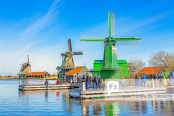 Zaanse schans  Niederlande  1. April 2016: Grüne bunte holländische Windmühlen im traditionellen Dorf  Touristen  blaür Himmel in Nordholland  Europa