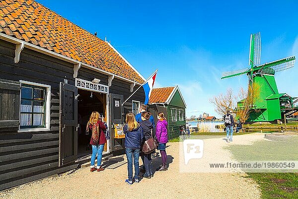 Zaanse schans  Niederlande  1. April 2016: Grüne bunte holländische Windmühle in traditionellem Dorf  Touristen  blaür Himmel in Nordholland  Europa
