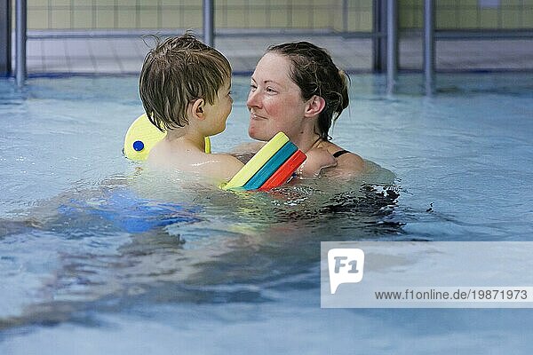Topic: Mother and child taking swimming lessons in the indoor pool