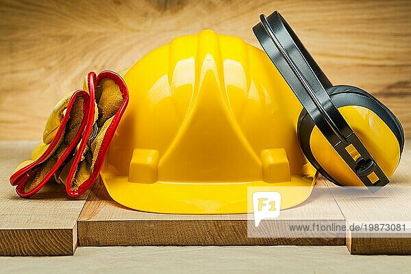 Arbeitshandschuhe aus Leder  gelber Helm und Kopfhörer. Sicherheitswerkzeuge