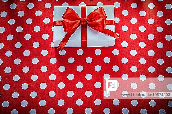 Geschenkbox auf gepunktetem rotem Stoff Feiern Konzept