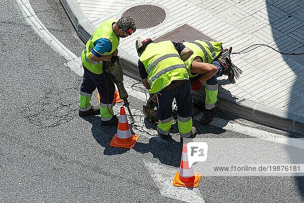 Eine Gruppe von Bauarbeitern repariert eine Asphaltstraße in der Stadt. Instandhaltung von Pflastersteinen