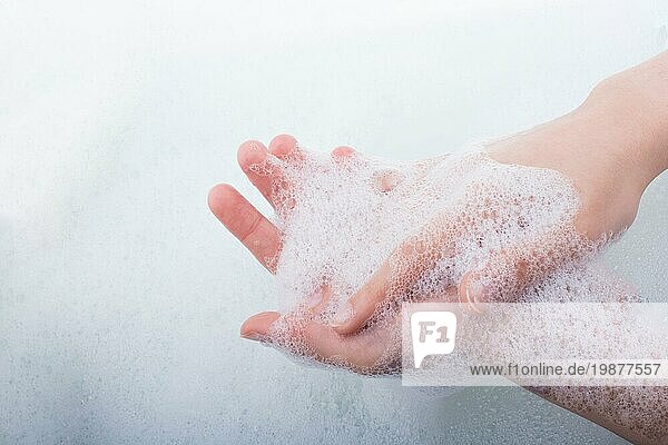 Händewaschen und Seifenschaum auf einem schaumigen Hintergrund