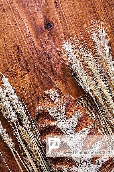 Brot und Weizenähren auf Vintageholzbrett Essen und Trinken Konzept