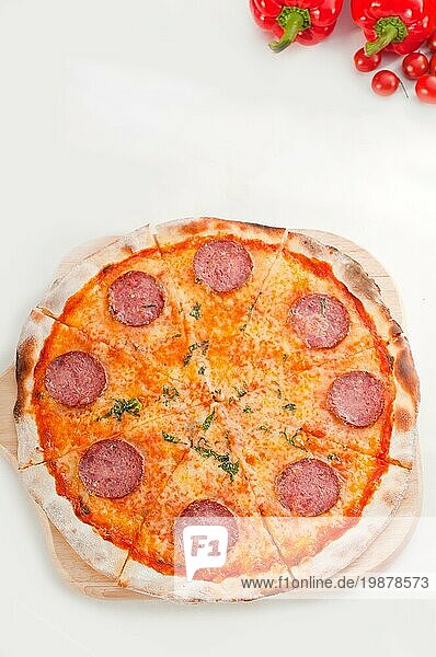 Italienische Original Peperoni Pizza mit dünner Kruste  vor weißem Hintergrund  Lebensmittelfotografie