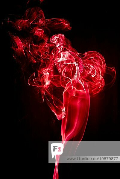 Roter Symbolbild geformter Rauch vor schwarzem Hintergrund. Abstrakter Hintergrund. Selektiver Fokus