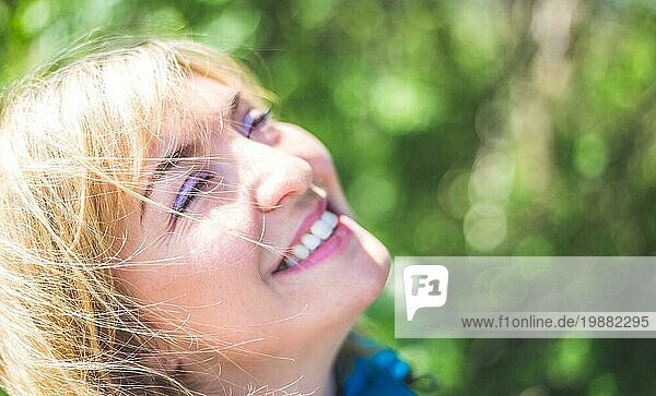 Porträt eines attraktiven jungen Mädchens im Freien  Frühling  unscharfer grüner Hintergrund