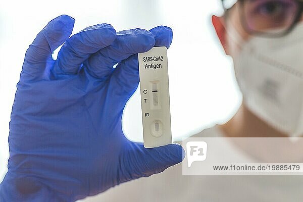 Nahaufnahme des Antigen Corona oder Covid 19 Tests in den Fingern eines jungen Biologen oder Pharmazeuten