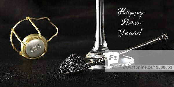 Frohes neues Jahr Panorama mit schwarzem Kaviar  einem Glas Champagner und einem Champagnerkorken mit der Zahl 2020  selektiver Fokus