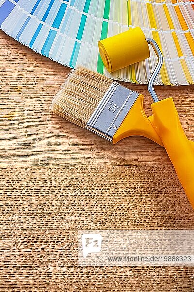 Farbroller Pinsel und Pantone Farbpalette Leitfaden auf Holzplatte Baukonzept