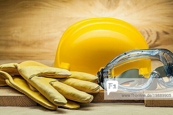 Arbeitshandschuhe aus Leder  gelber Helm und durchsichtige blaue Schutzbrille