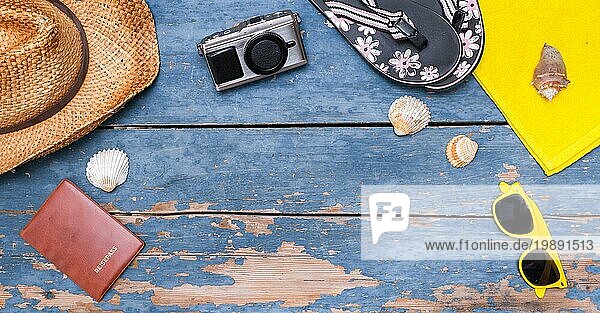 Sommerlicher Hintergrund: Konzept der Freizeitreise im Sommer: Strohhut  Sonnenbrille  Muscheln  VintageKamera Reisepass und Flip Flops. Kopierraum