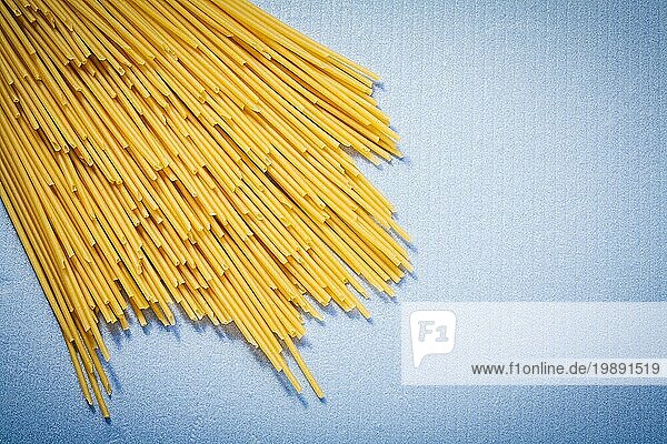 Lange ungekochte Spaghetti auf blauem Hintergrund Essen und Trinken Konzept