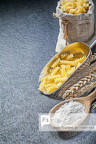 Burlap Sack rohe Nudeln servieren Schaufel Holzlöffel Mehl Weizen Roggen Ohren auf schwarzem Hintergrund