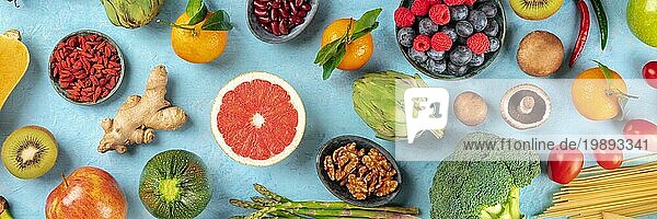 Vegane Lebensmittel Panorama auf einem blaün Hintergrund  top shot. Gesunde Ernährung Konzept. Obst  Gemüse  Nüsse  ein Flatlay
