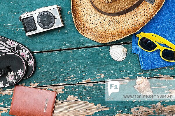 Sommerlicher Hintergrund: Konzept der Freizeitreise im Sommer: Strohhut  Sonnenbrille  Flip Flops  Muscheln  VintageKamera Handtuch und Reisepass