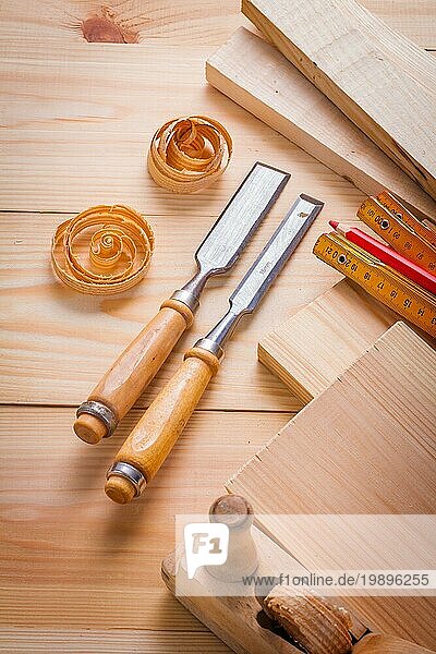 Zimmermannsmeißel und andere Werkzeuge auf Holzplatten Baukonzept